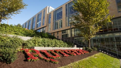 Academic building in the background with Rutgers spelled out in the lawn in the foregrown