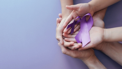 Hands cupping domestic violence ribbon