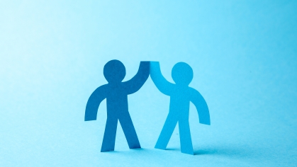 illustration of a paper person cutout high-fiving another paper person cutout