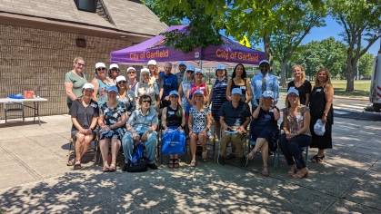 Staged photo of group of people outdoors in front of an organizational tent