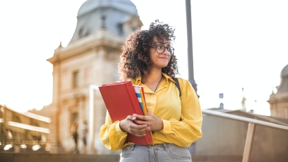 female college student on campus holding books