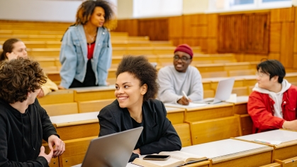 group of college students talking in lecture hall