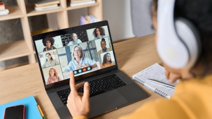 Person wearing headphone while watching a webinar