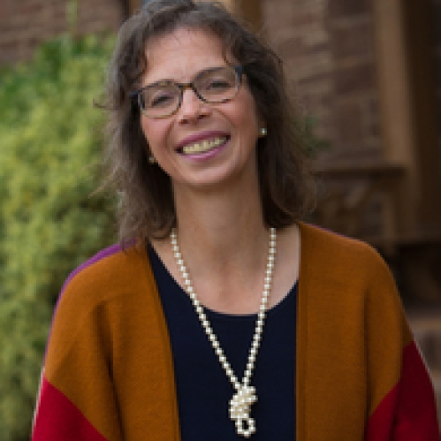 White woman with a cardigan sweater and necklace smiling