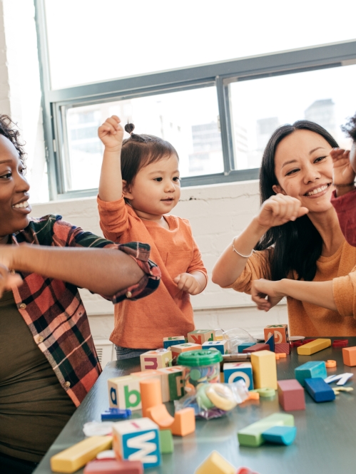 two teachers playing with two preschool children