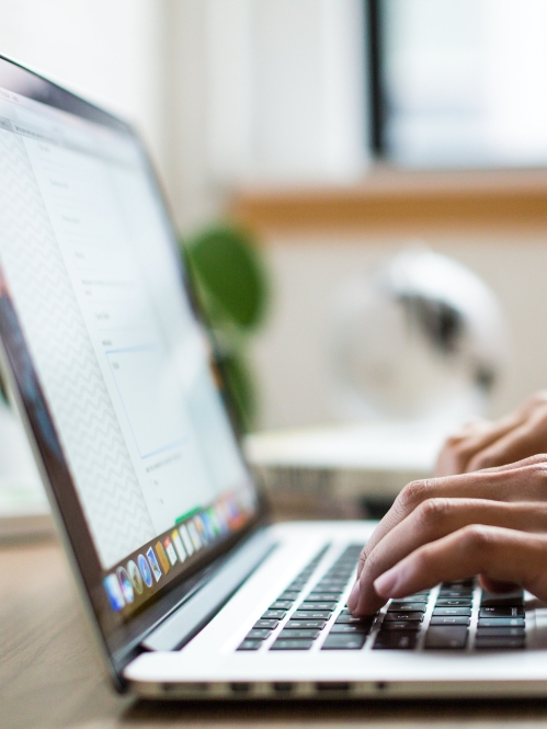 close up of man's hands typing on laptop