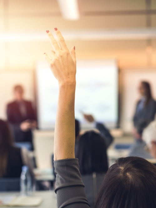 woman raising her hand in adult education class