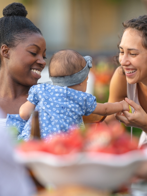 women holding and talking to baby at farmer's market