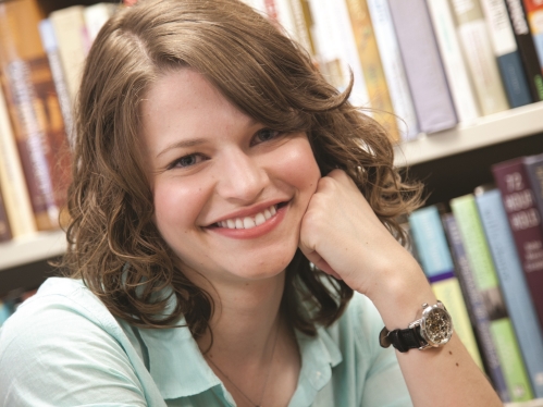 Similing girl in sitting in library