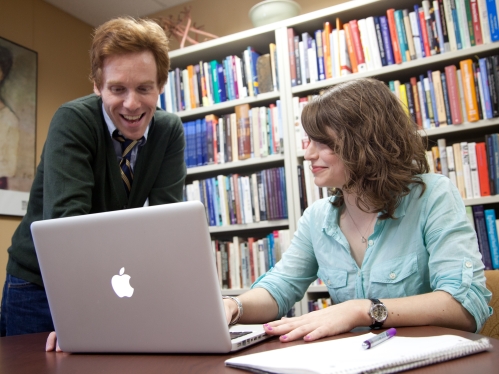 Students facing laptop