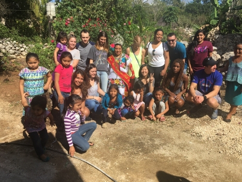 Group of people outside posed in a half circle to take a photo