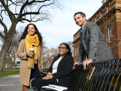 Three adults outside on campus