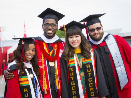 four students in rutgers graduation cap and gowns