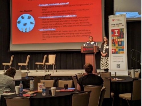 Two speakers on stage at conference in front of powerpoint slide